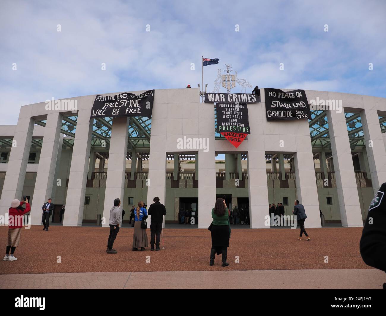 4. Juli 2024, Australien, Canberra, Parlamentsgebäude. Pro-palästinensische Demonstranten klettern auf das Dach des australischen Parlaments, um Banner zu entfalten, die die Rolle der australischen Regierung bei der Förderung des Völkermords in Gaza kritisieren Stockfoto