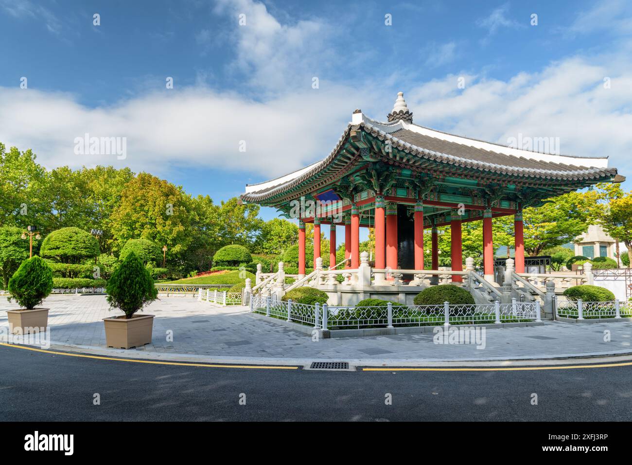Farbenfroher Glockenpavillon mit traditioneller koreanischer Architektur auf blauem Himmel im Yongdusan Park in Busan, Südkorea. Malerische, sonnige Stadtlandschaft. Stockfoto