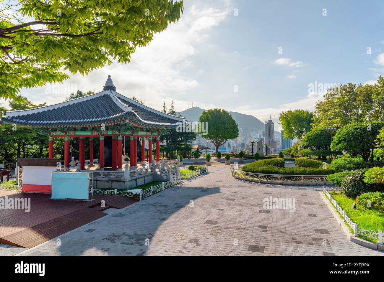 Farbenfroher Glockenpavillon mit traditioneller koreanischer Architektur auf blauem Himmel im Yongdusan Park in Busan, Südkorea. Malerische, sonnige Stadtlandschaft. Stockfoto
