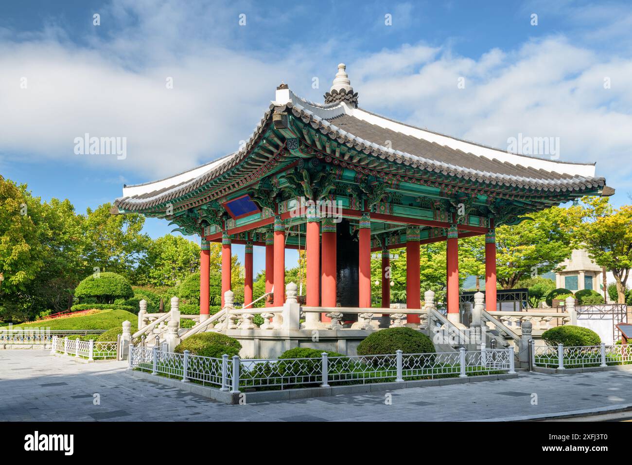 Farbenfroher Glockenpavillon mit traditioneller koreanischer Architektur auf blauem Himmel im Yongdusan Park in Busan, Südkorea. Malerische, sonnige Stadtlandschaft. Stockfoto