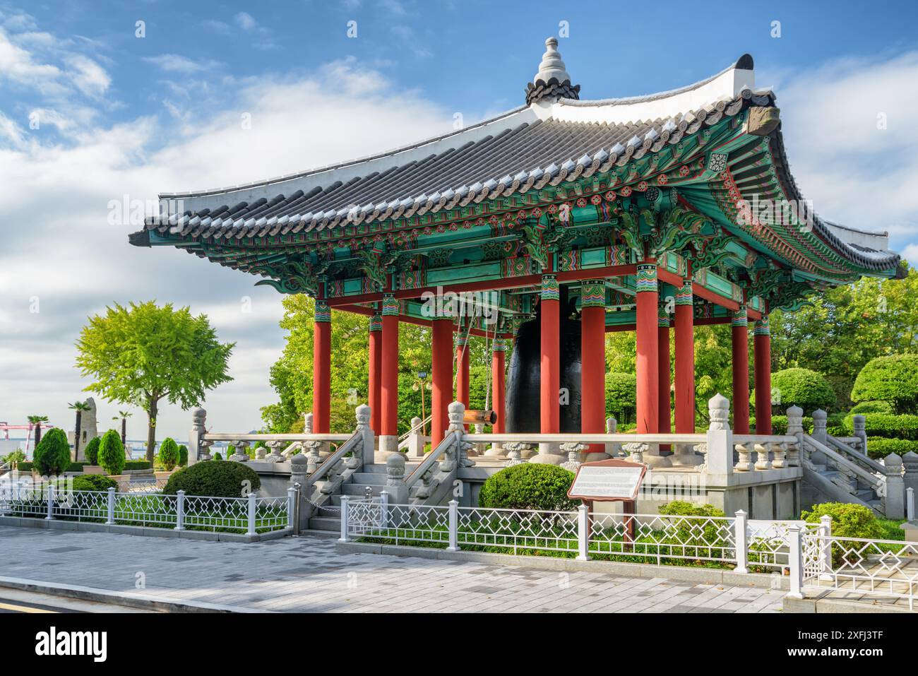 Farbenfroher Glockenpavillon mit traditioneller koreanischer Architektur auf blauem Himmel im Yongdusan Park in Busan, Südkorea. Malerische, sonnige Stadtlandschaft. Stockfoto