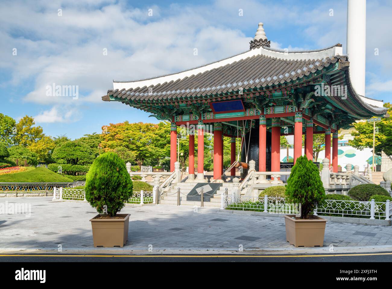 Farbenfroher Glockenpavillon mit traditioneller koreanischer Architektur auf blauem Himmel im Yongdusan Park in Busan, Südkorea. Malerische, sonnige Stadtlandschaft. Stockfoto
