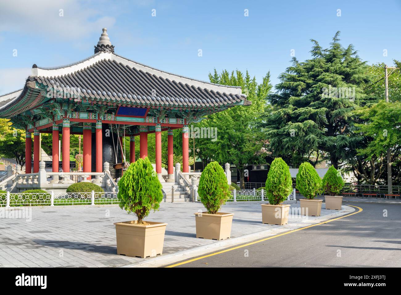 Farbenfroher Glockenpavillon mit traditioneller koreanischer Architektur auf blauem Himmel im Yongdusan Park in Busan, Südkorea. Malerische, sonnige Stadtlandschaft. Stockfoto