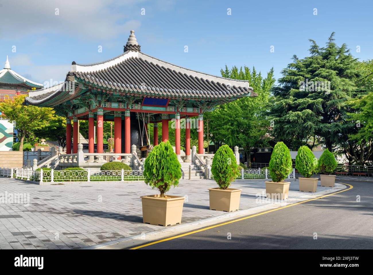 Farbenfroher Glockenpavillon mit traditioneller koreanischer Architektur auf blauem Himmel im Yongdusan Park in Busan, Südkorea. Malerische, sonnige Stadtlandschaft. Stockfoto