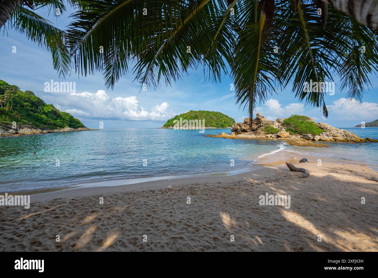 Blauer Himmel über einer kleinen Insel, umgeben von blauem Meer. Weißer Strand mit Kokospalmen. Yanui Beach, ein Aussichtspunkt neben Promthep Cape und Windmühle Stockfoto
