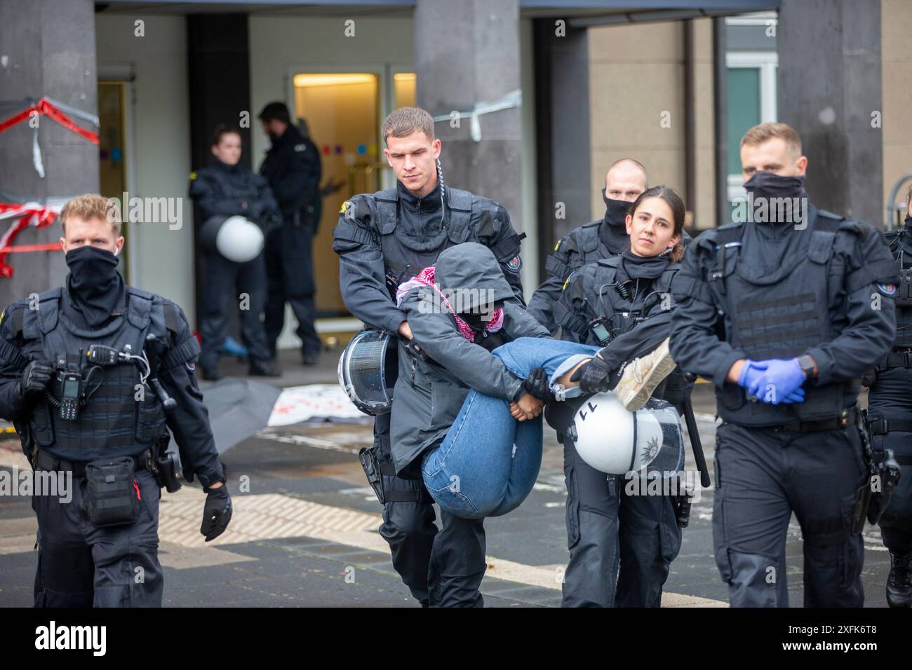 Köln, Deutschland. Juli 2024. Blockade des Haupteingangs zur Universität durch pro-palästinensische Aktivisten. Maskierte Demonstranten werden von der Polizei mitgenommen. Quelle: Thomas Banneyer/dpa/Alamy Live News Stockfoto