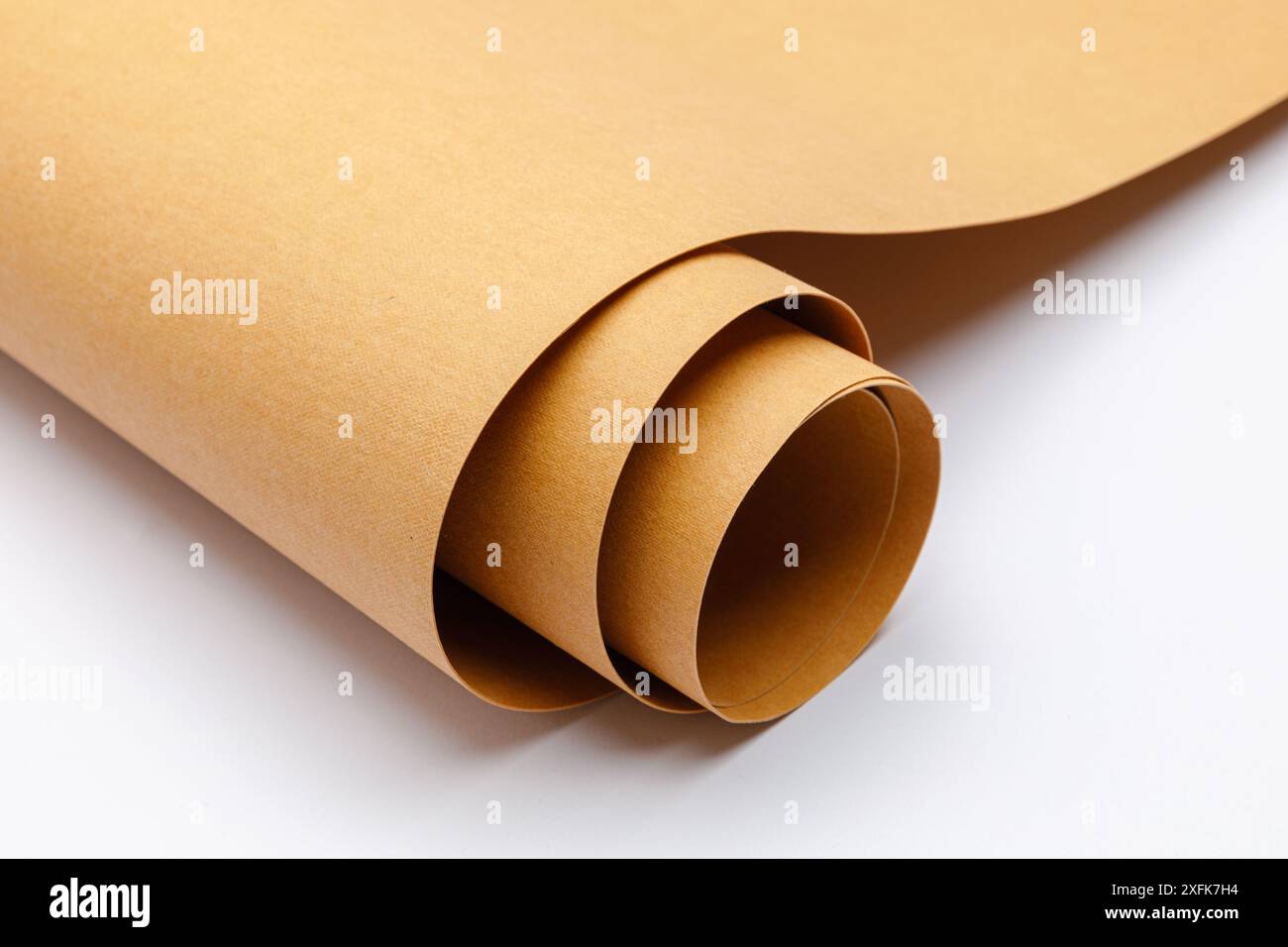 Nahaufnahme von aufgerolltem braunem waschbarem Kraftpapier auf weißem Hintergrund mit Kopierraum Stockfoto