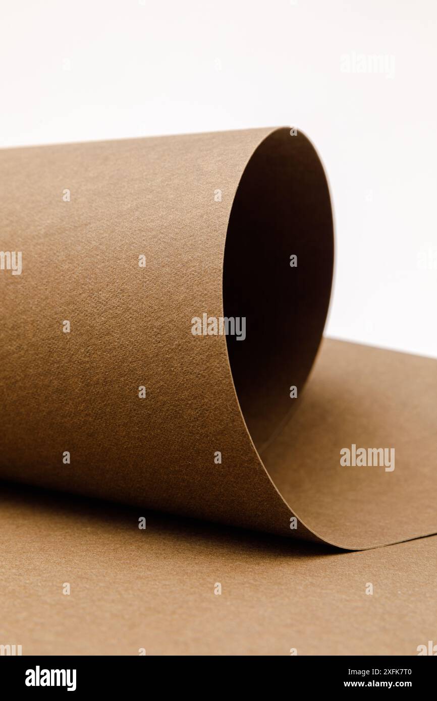 Nahaufnahme von aufgerolltem braunem waschbarem Kraftpapier auf weißem Hintergrund mit Kopierraum Stockfoto