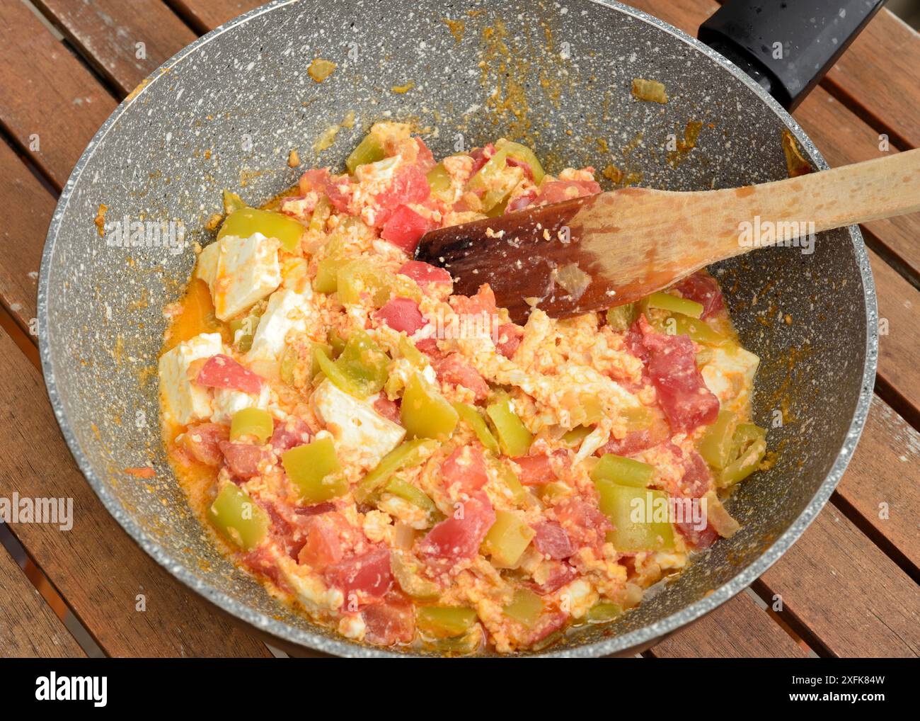 Einfaches hausgemachtes Gericht in der Pfanne gebratene Paprika und Tomaten mit griechischem Käse in der Pfanne Stockfoto