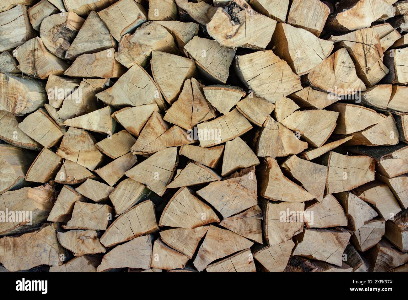 Gehacktes und stapeltes Feuerholz für die Winterheizung, Brennstofflagerung für den Ofen für kalte Tage, Vollrahmen Stockfoto