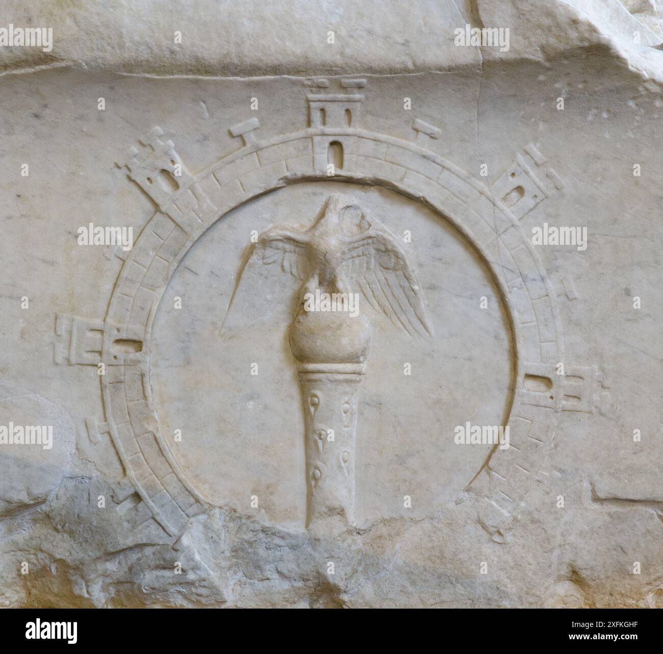 Römisches Marmorrelief mit einer Festung mit Toren und Türmen, das als Kranz verwendet wird, der einen siegreichen Adler auf einer Kugel und einem Zepter umgibt. Stockfoto