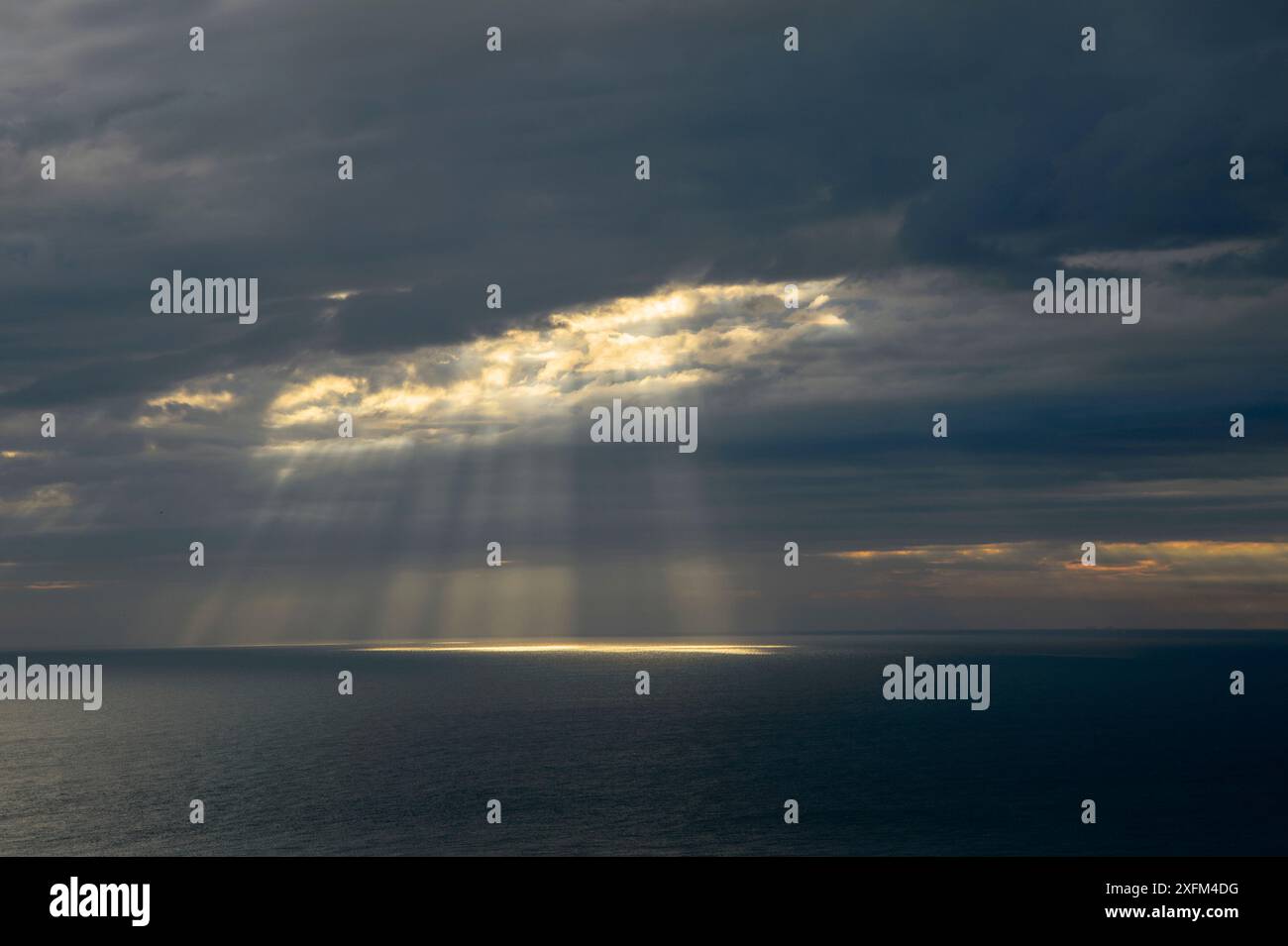 Sonnenstrahlen brechen durch dunkle Wolken über dem Meer, englischer Kanal, Kent, Großbritannien. Juli Stockfoto