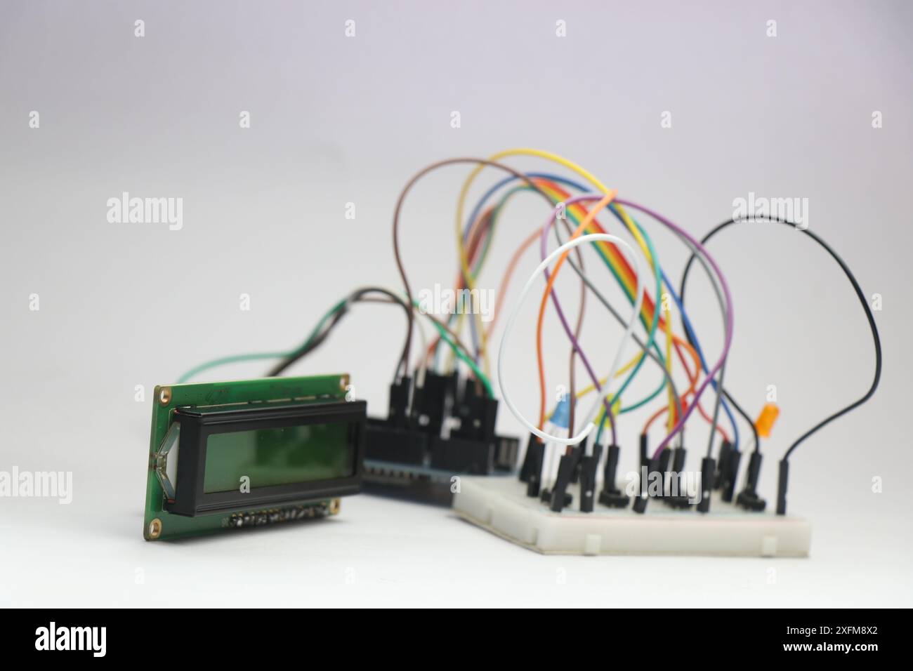 LCD-Modul, das an den programmierbaren Controller angeschlossen ist, der die LED auf der Steckplatine steuert. Brotboard-Prototyp mit Überbrückungsdrähten Stockfoto