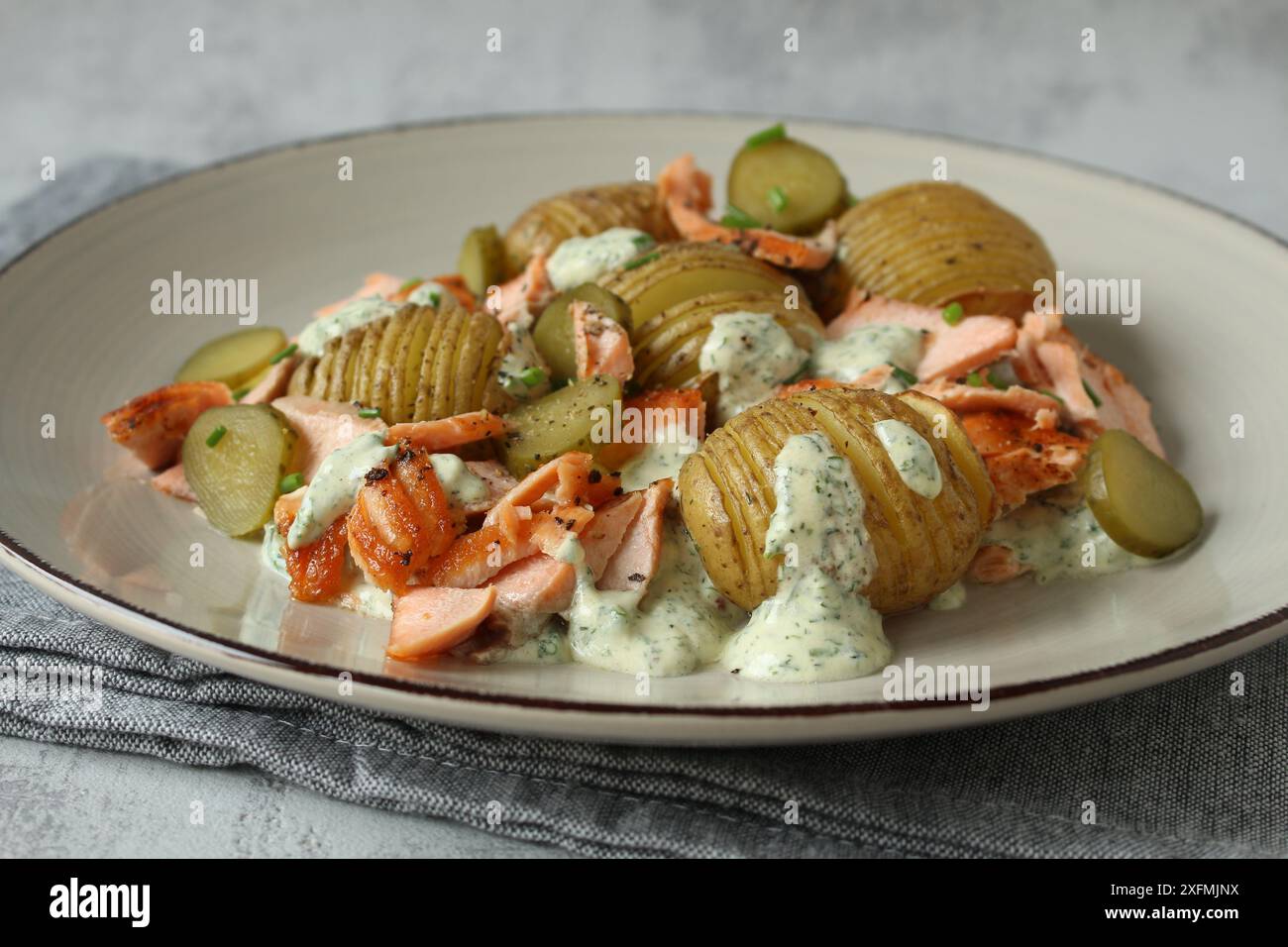 Hasselback Kartoffelsalat mit Gurken und Lachsforelle Stockfoto