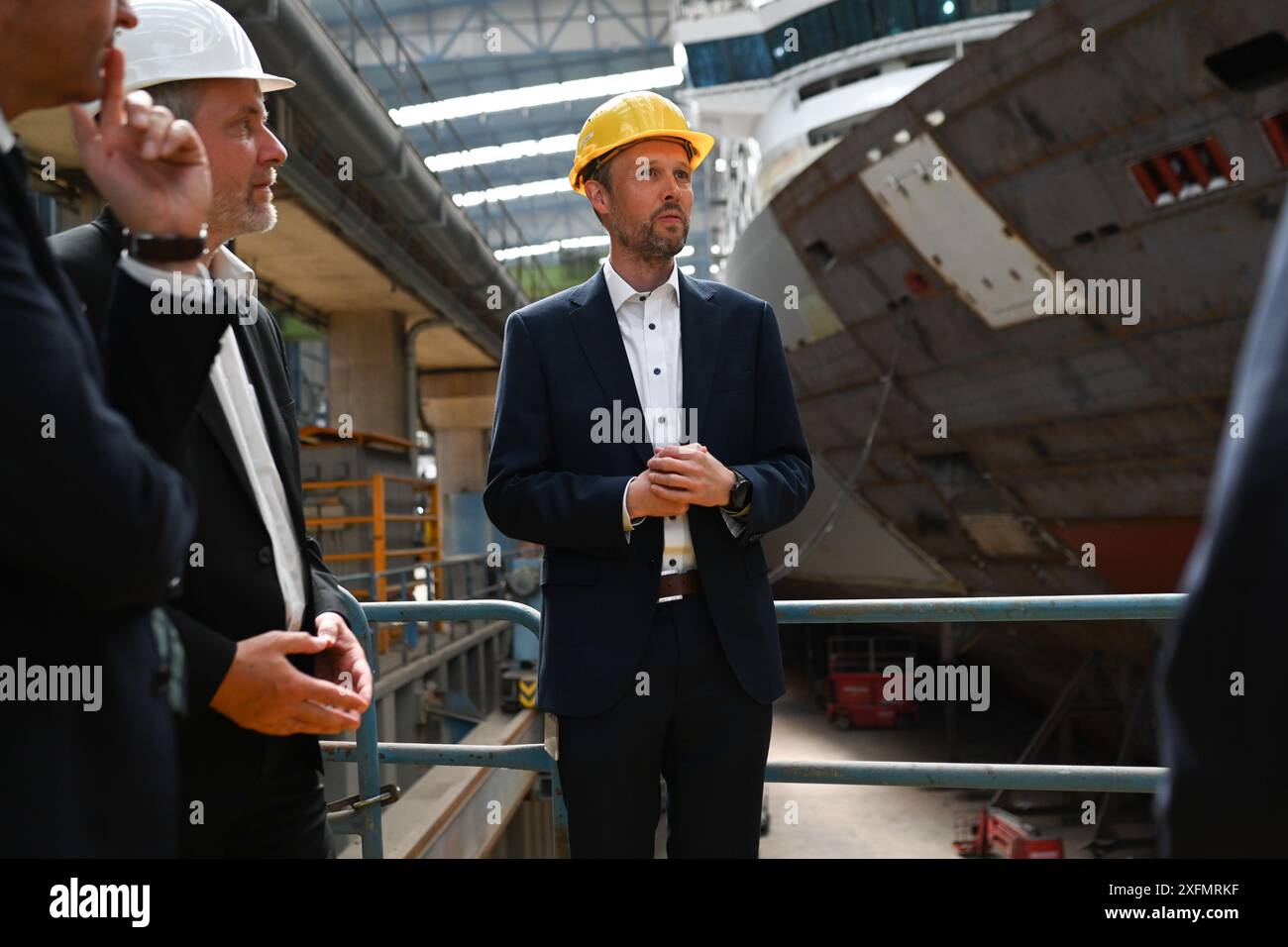 Papenburg, Deutschland. Juli 2024. Tim Meyer, ehemaliger CEO der Meyer Werft, zeigt politische Vertreter rund um die Werft. Die Meyer Werft betritt das Offshore-Geschäft und baut auf hoher See sogenannte Konverterplattformen für Windräder. Die Arbeiten am Stahlbau der DolWin-Delta-Konverterplattform auf der Werft haben nun begonnen. Quelle: Lars Penning/dpa/Alamy Live News Stockfoto