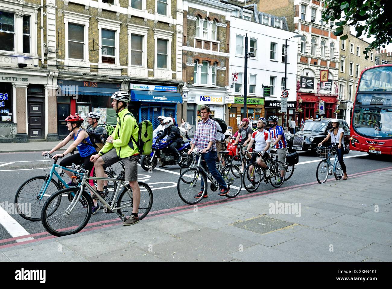 Pendler-Radfahrer in fortgeschrittener Haltespur mit Bus dahinter, London Borough of Islington, England, Großbritannien, Juli 2015. Stockfoto