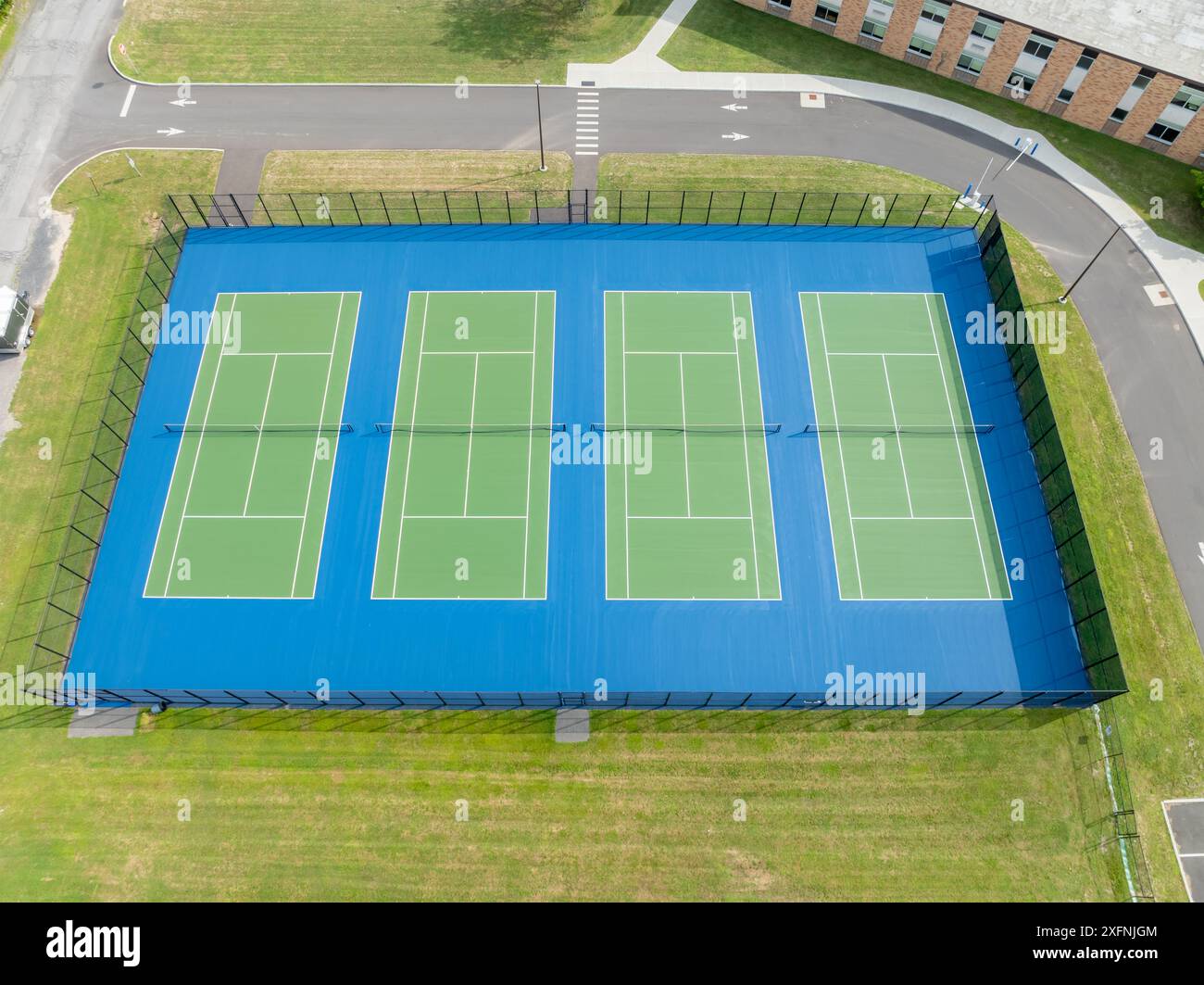 Luftfahrt, Drohne, Foto von neuen grünen Tennisplätzen im Freien mit weißen Linien und blauem außerhalb der Grenzen. Stockfoto