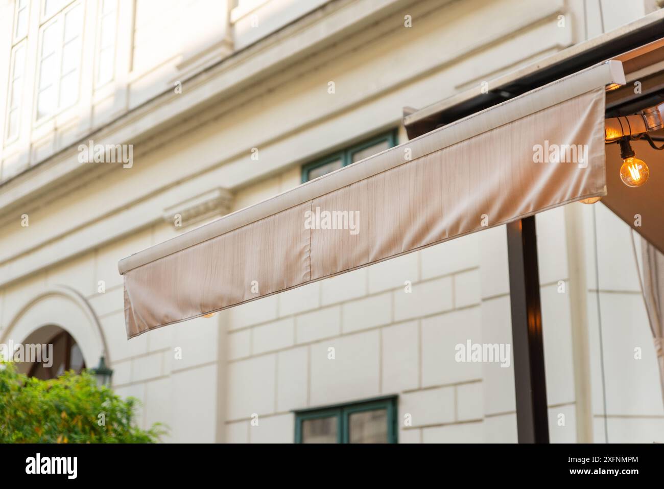 Modernes beigefarbenes Markise auf dem City-Shop zur Werbung für das Shop-Logo. Stilvolle städtische Werbelösung für Branding und Sichtbarkeit der Ladenfront Stockfoto