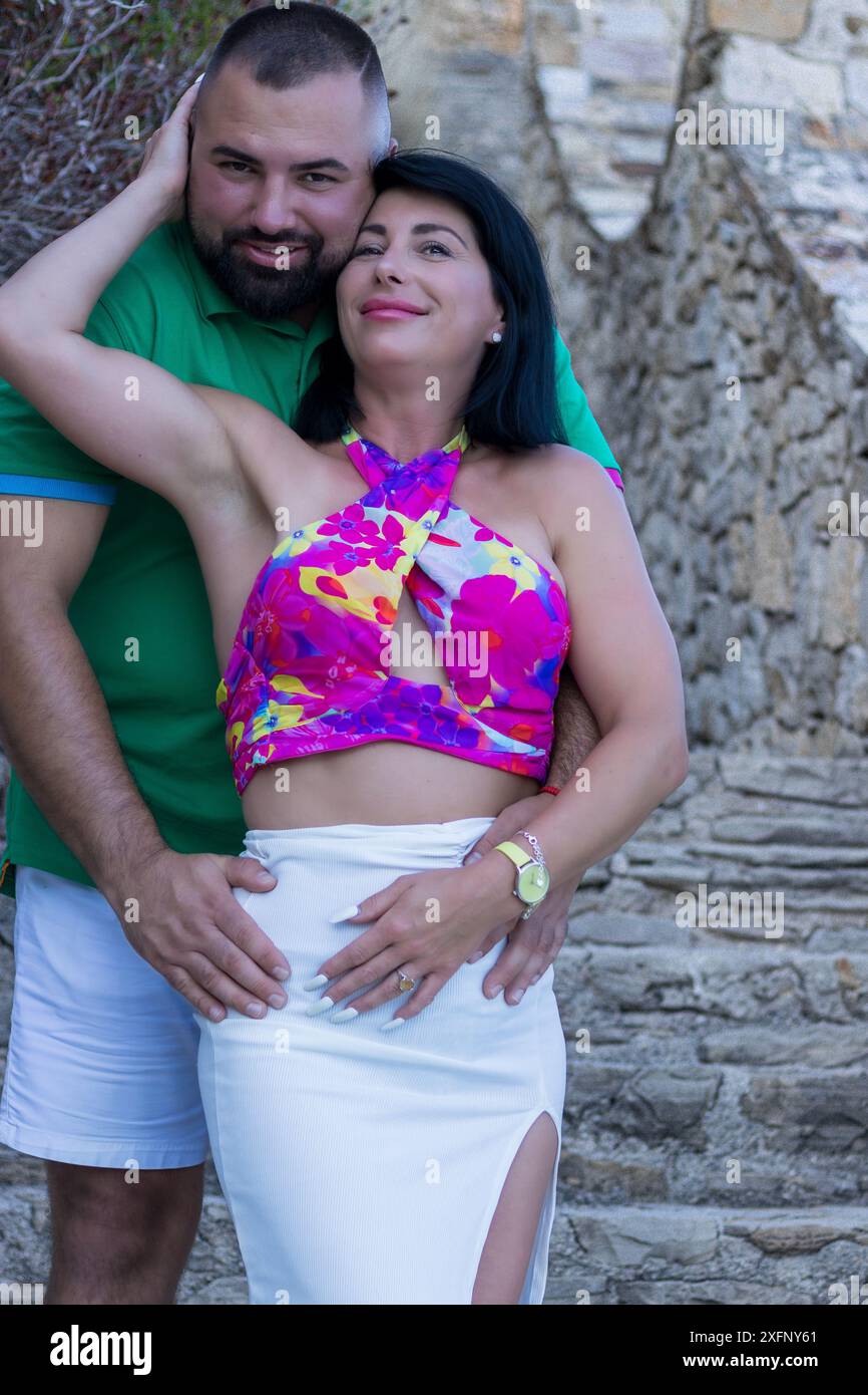 Dieses Bild zeigt einen herzerwärmenden Moment eines Mannes und einer Frau, die sich auf Steinstufen umarmen. Stockfoto