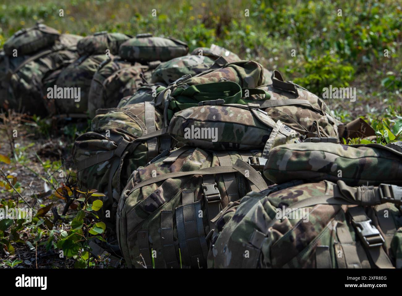 Rucksäcke mit Tarnmuster der 11. Division der US Army lagen am Boden in Fort Greely, Alaska während der Red Flag-Alaska 24-2 am 5. Juni 2024. Die Übung bot einzigartige Möglichkeiten, verschiedene Schwerpunkte in gemeinsame, kombinierte Schulungen aus simulierten Vorwärtsoperationen zu integrieren. Stockfoto