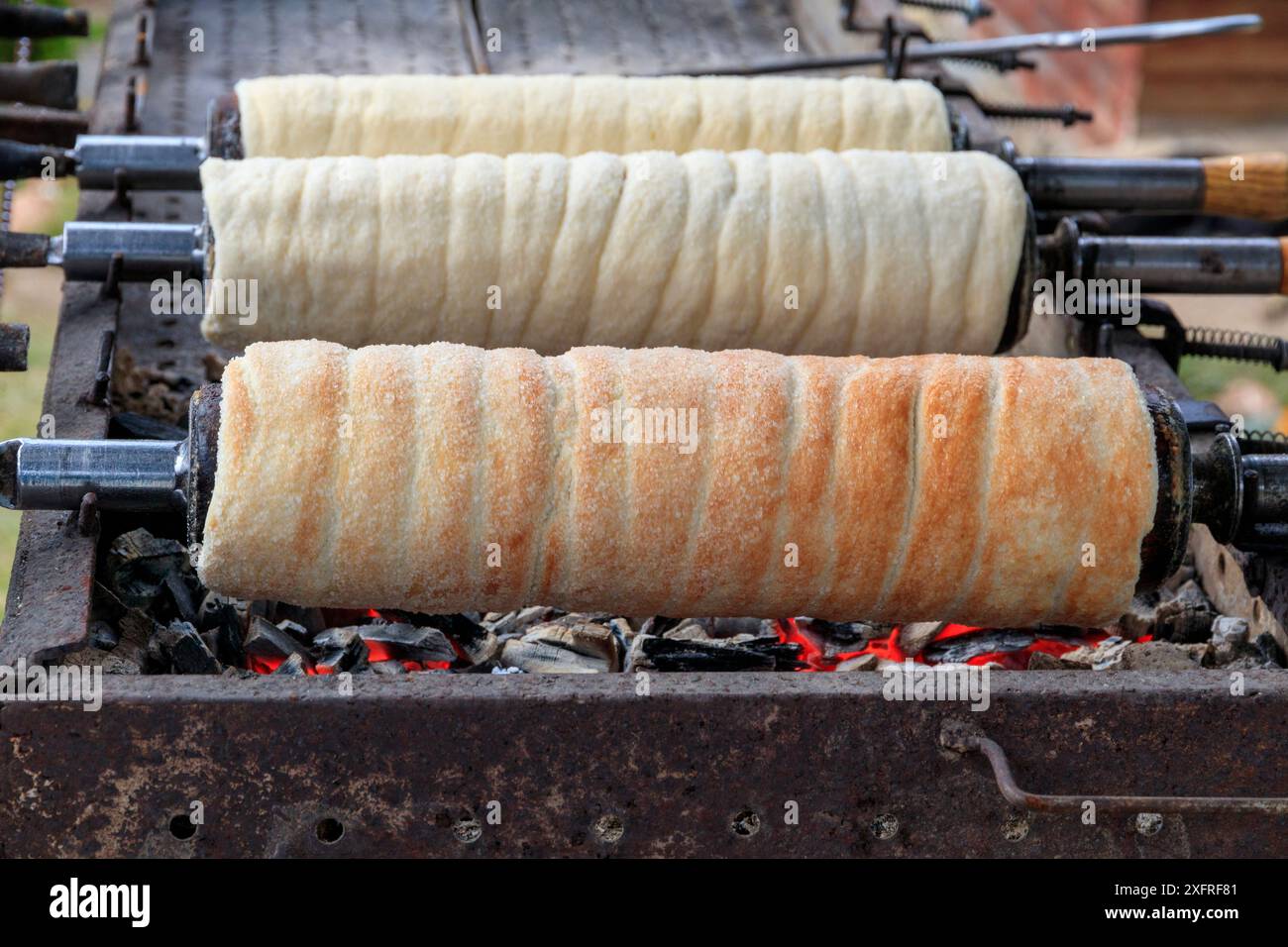 Europa, Rumänien. Bicazului Gorges und Red Lake Region. Rumänien, traditionelle Donuts, Kaminkuchen, Kurtoskalacs. Geröstet auf einem Stock. Stockfoto