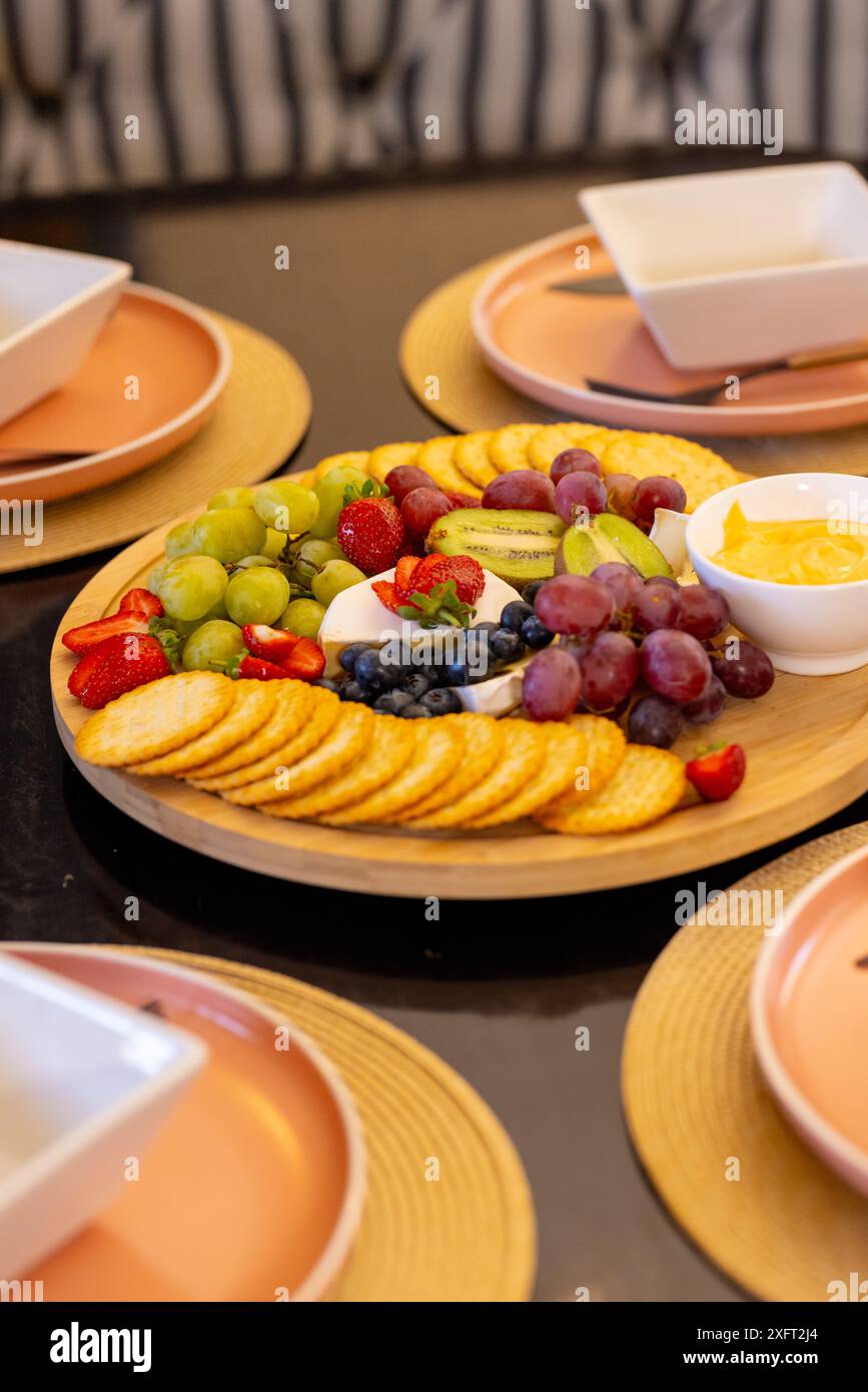 Auf dem Esstisch werden bunte Früchte und Cracker-Platten für verschiedene Freunde serviert, Kopierraum Stockfoto