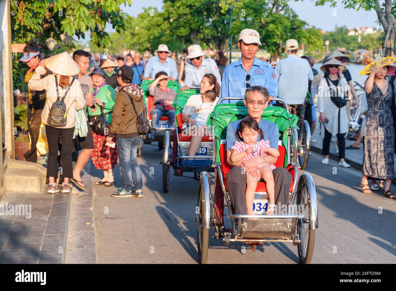 Hoi an (Hoian), Vietnam - 11. April 2018: Asiatische Touristen reiten Trischas (Radrikschas) in der antiken Stadt Hoi an. Stockfoto