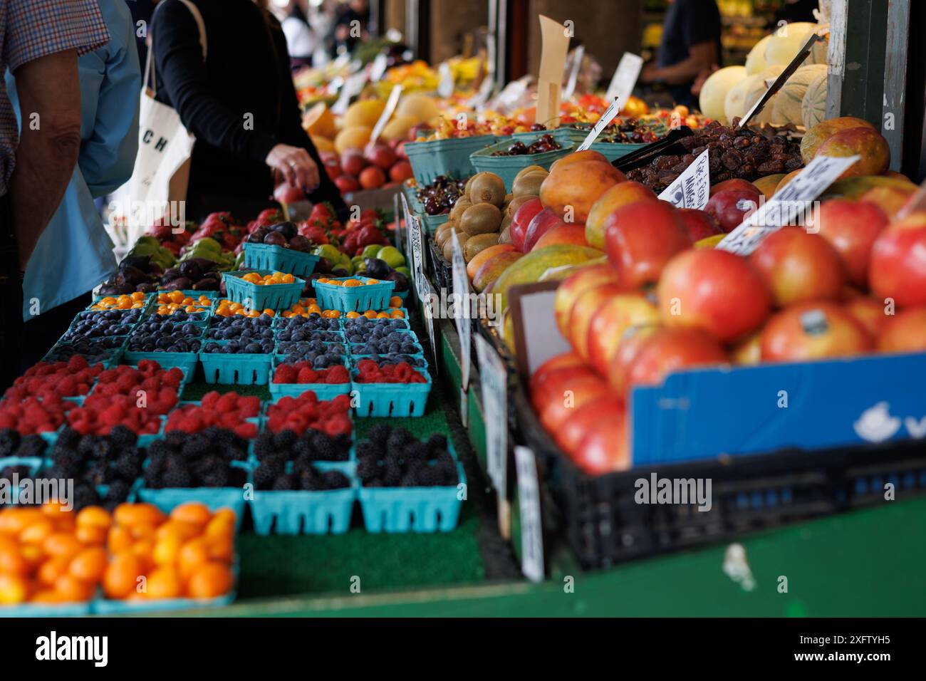 Lebendiger Obststand mit verschiedenen Beeren und Früchten. Stockfoto