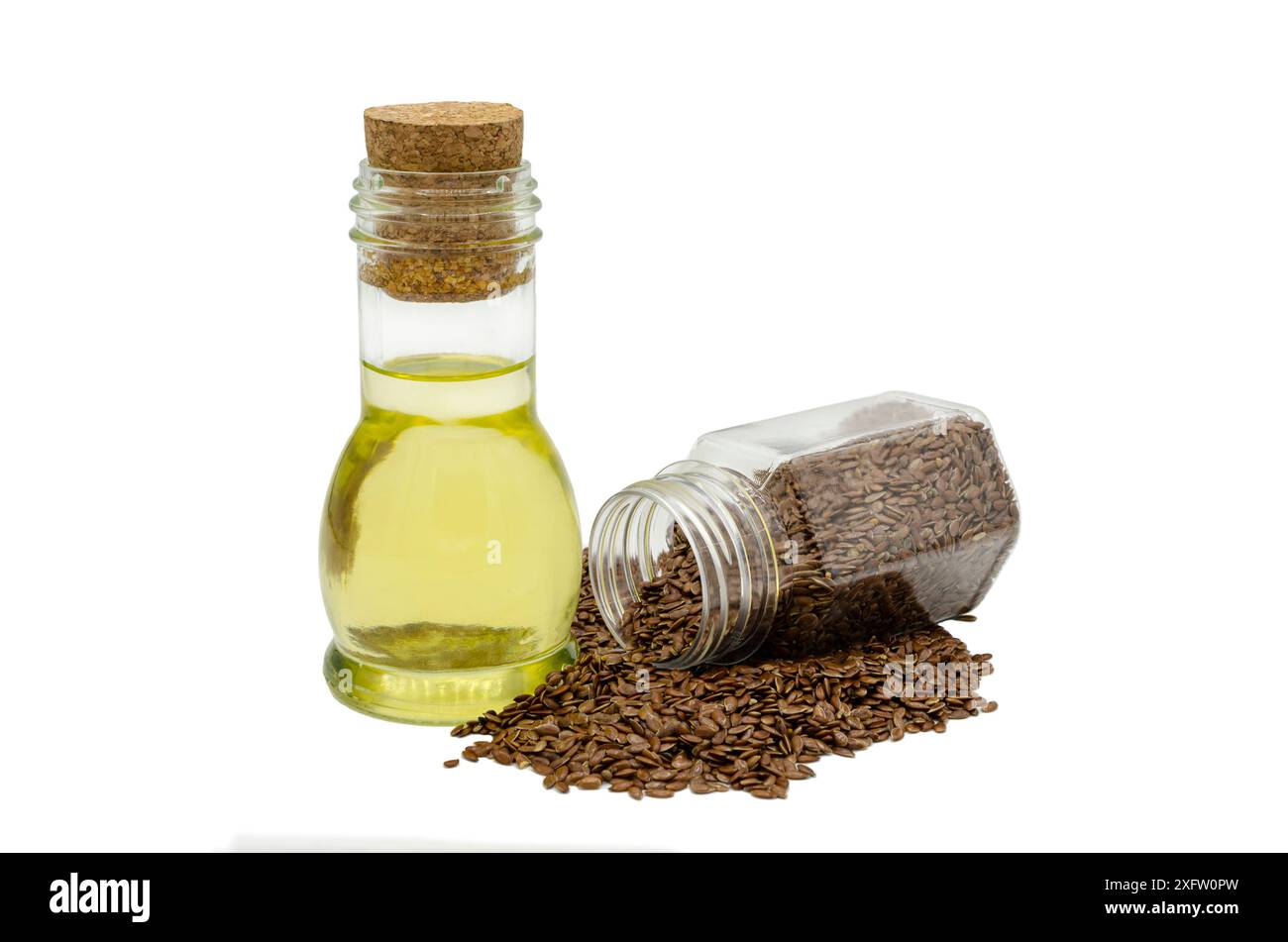 Rohe Leinsamen in einem transparenten Behälter und Leinöl in einer Glasflasche auf weißem Hintergrund. Stockfoto