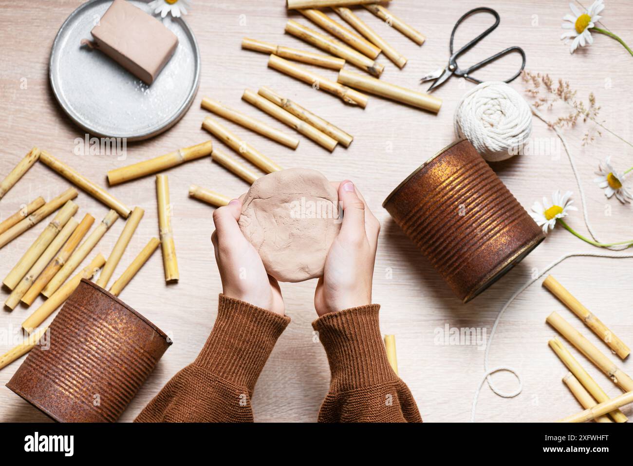 Schritt 2: Bilden Sie mit der Hand eine runde, flache Schicht aus luftgetrocknetem Ton. Erstellen Sie ein DIY-Bug-Hotel für den Garten. Kinder basteln und helfen Wildtieren Konzept. Stockfoto