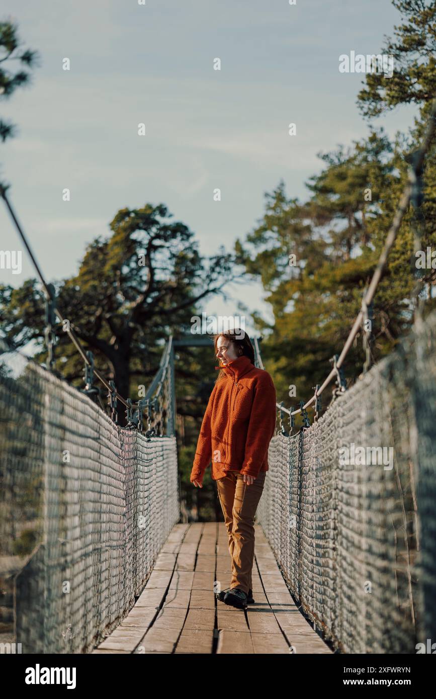 Die ganze Länge einer jungen Frau, die auf der Brücke steht Stockfoto