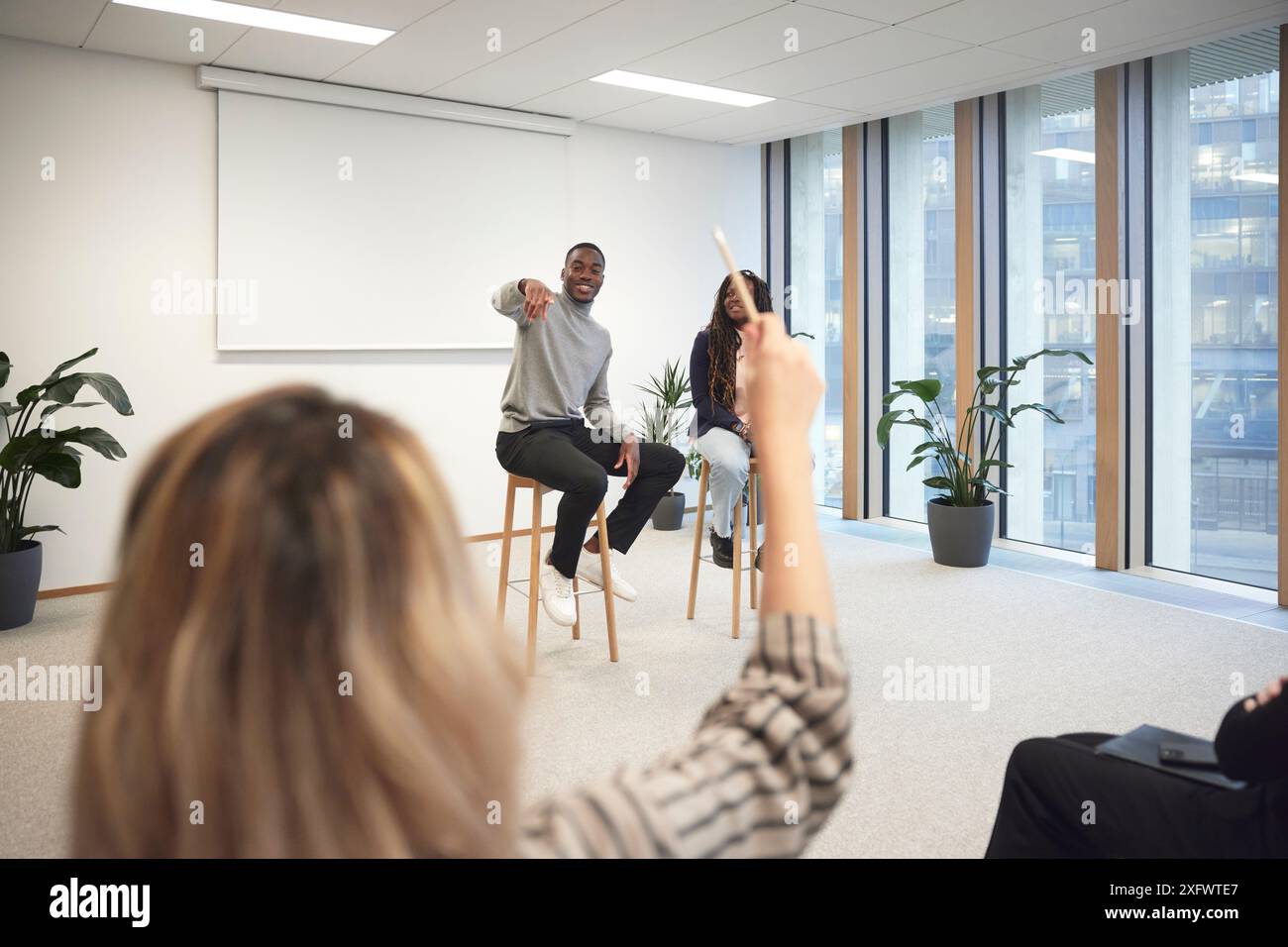 Geschäftsmann, der auf einen Kollegen zeigt, um Fragen während der Besprechung im Büro zu stellen Stockfoto