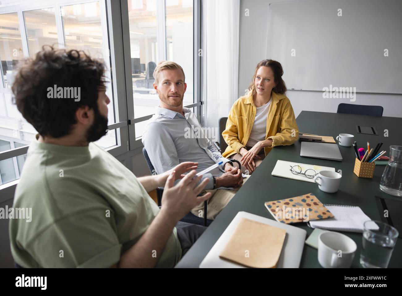 Geschäftsmann diskutiert Ideen mit Kollegen im Büro Stockfoto