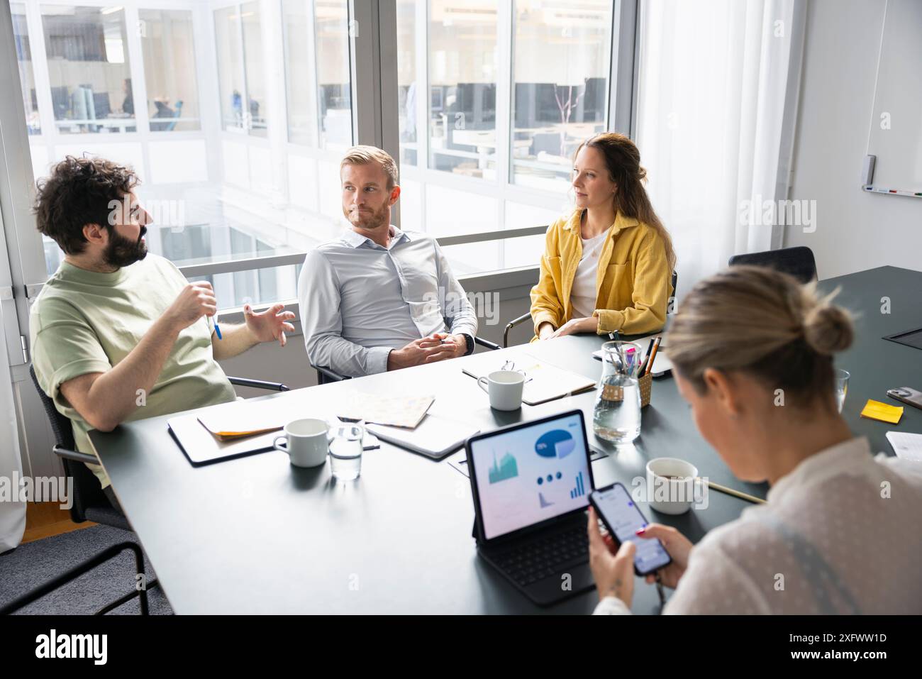 Gruppe von Geschäftsleuten, die Ideen am Konferenztisch im Büro diskutieren Stockfoto