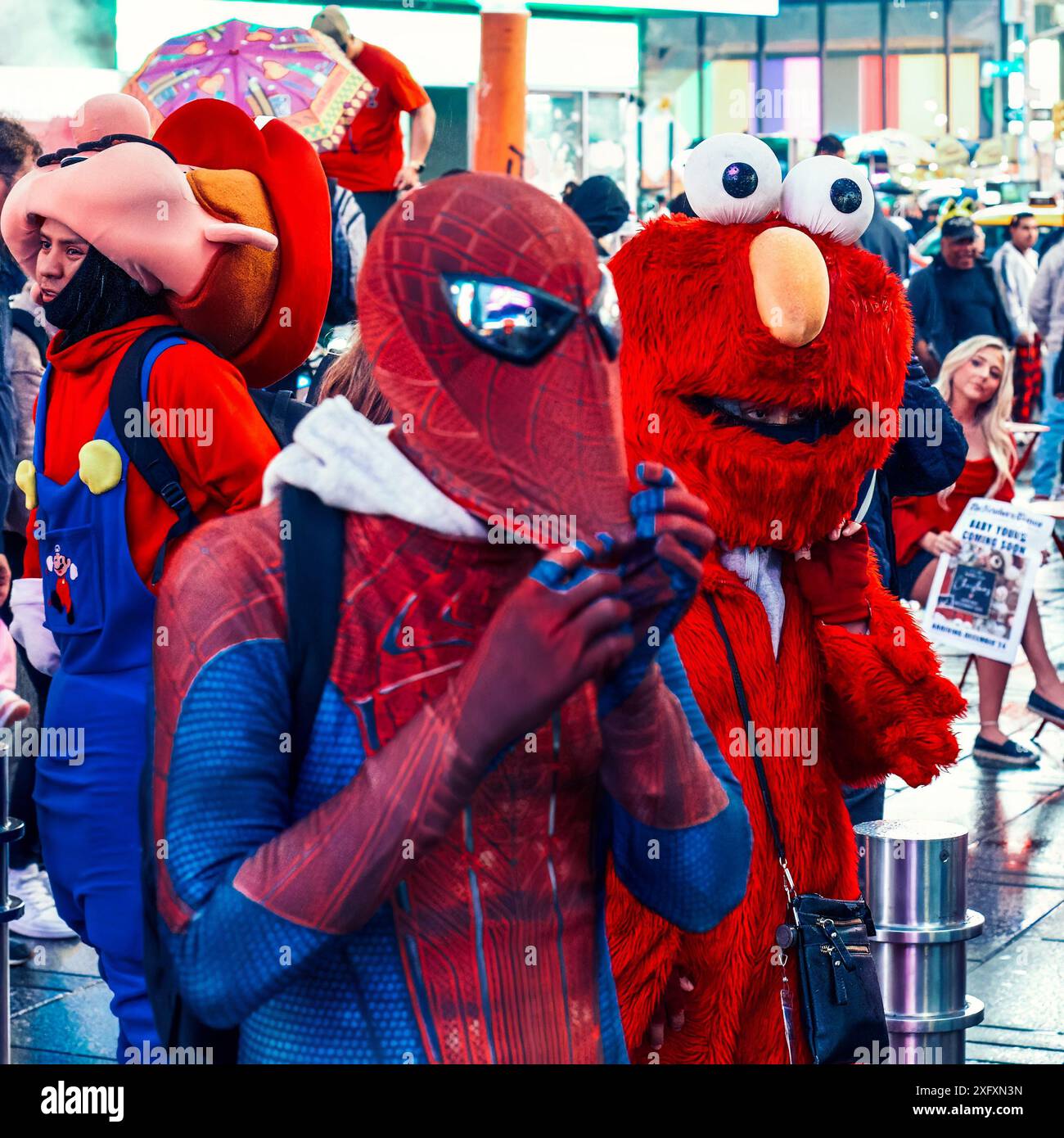 New York, USA – 19. Mai 2024: Eine als Spider-man gekleidete Person steht neben einer als Elmo gekleideten Person auf dem Times Square, beide mit Blick auf die Kamera Stockfoto