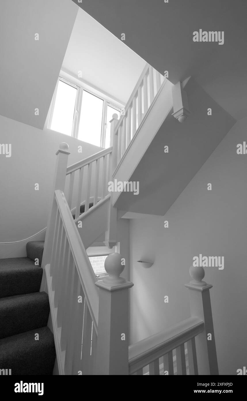 Renovierte, weiß lackierte Holztreppe mit einfachen vertikalen Leisten, in einem edwardianischen Haus im Nordwesten Londons, Großbritannien. Stockfoto Renovierte, weiß lackierte Holztreppe mit einfachen vertikalen Leisten, in einem edwardianischen Haus im Nordwesten Londons, Großbritannien. Stockfoto