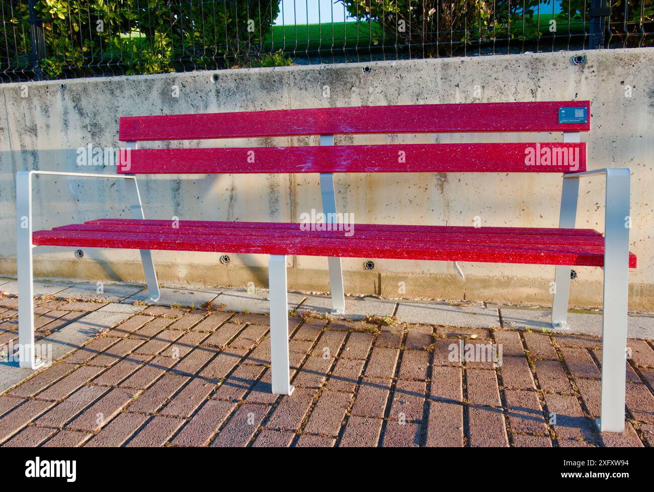 Recycelte Kunststoff-Debit- und Kreditkarten von Banco Santander für öffentliche Straßen rote Bänke Santander Cantabria Spanien Stockfoto