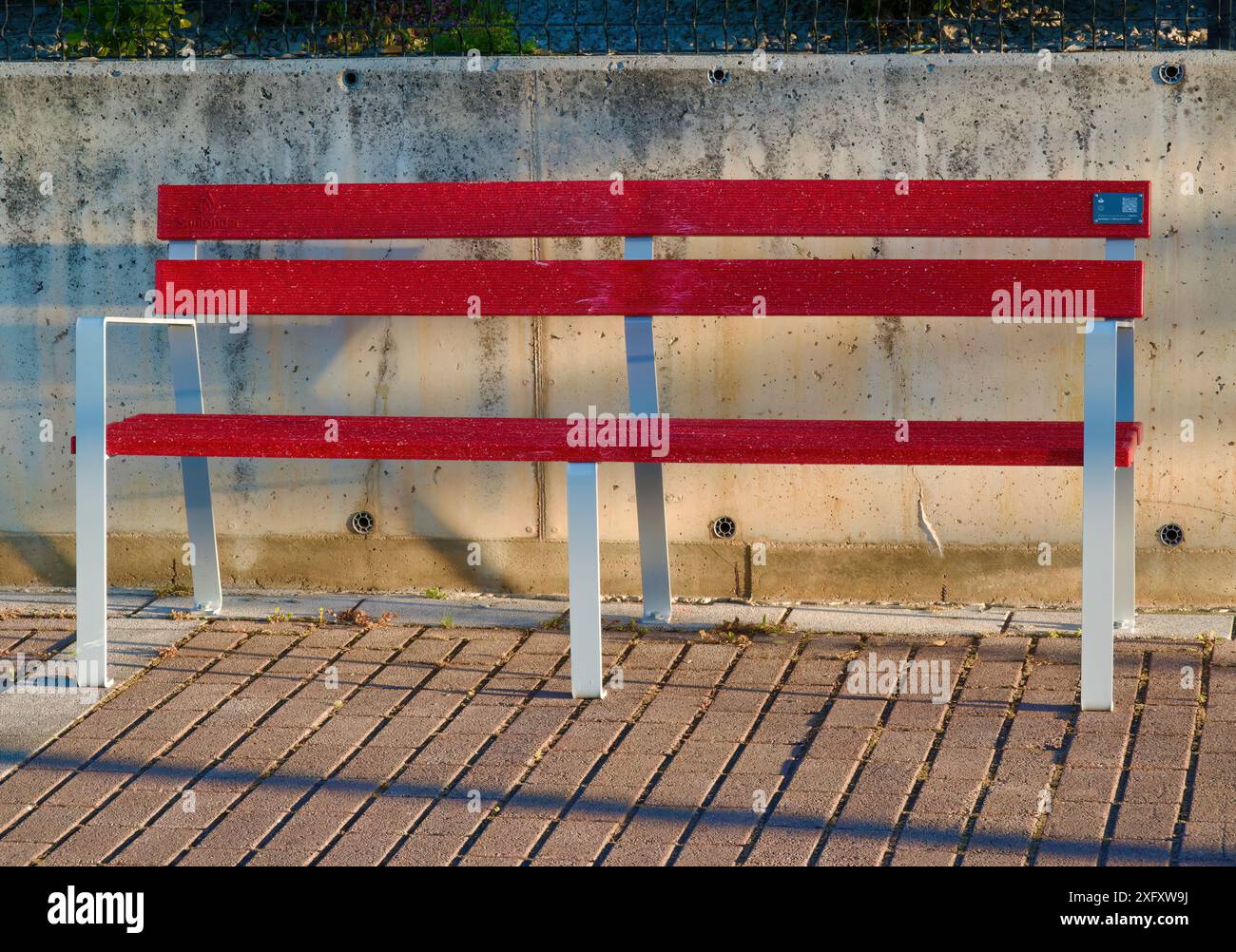 Recycelte Kunststoff-Debit- und Kreditkarten von Banco Santander für öffentliche Straßen rote Bänke Santander Cantabria Spanien Stockfoto