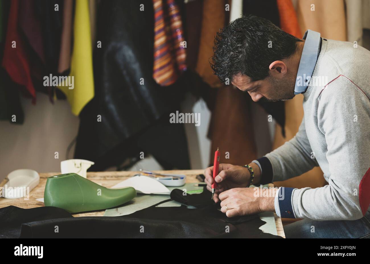 Nahaufnahme von einem Schuhmacher schneiden Leder. Konzept der schuhe designer. Stockfoto