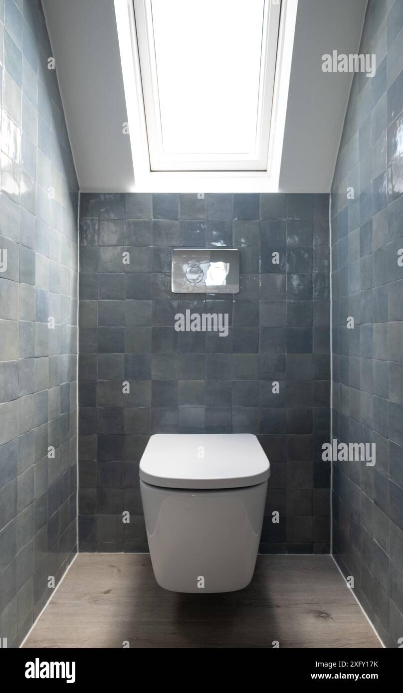 Kleine Toilette in Loft-Umbau mit cleverem Gebrauch der Traufe auf dem Dachboden. Architekt entworfen mit blauen Porzellan zellige Fliesen, weiße Wand hängende Toilette. Stockfoto