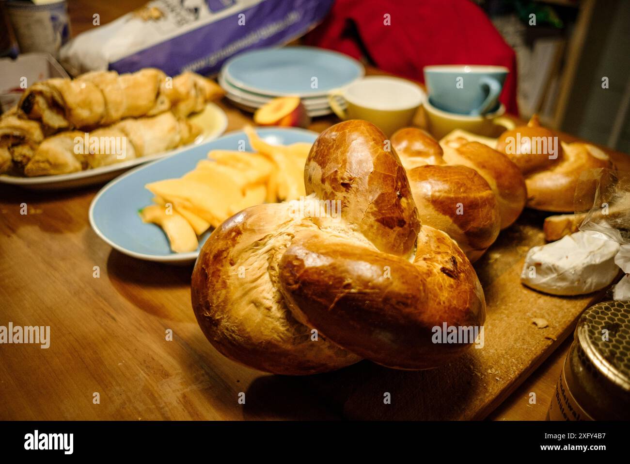 Traditionelles Schweizer Butterzopf geflochtenes Brot in einem Haus auf Holztisch mit warmem Licht. Konzept der Schweizer Bäckereitradition Stockfoto