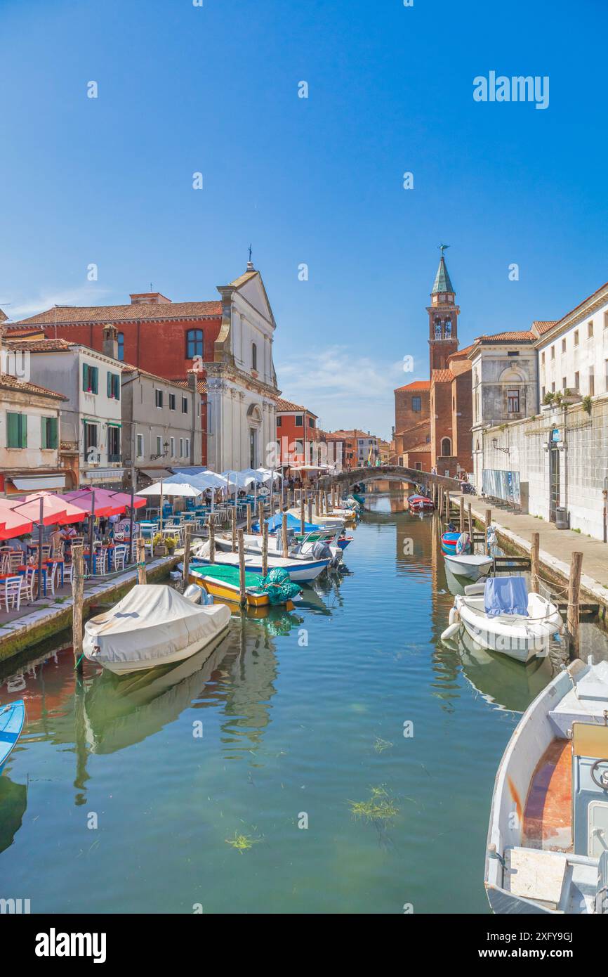 Die Kanalvene mit verankerten mehrfarbigen Booten, die Filippini-Kirche, der Glockenturm der Kirche San Giacomo Apostolo, Chioggia, Stadt der Metropolstadt Venedig, Veneto, Italien Stockfoto