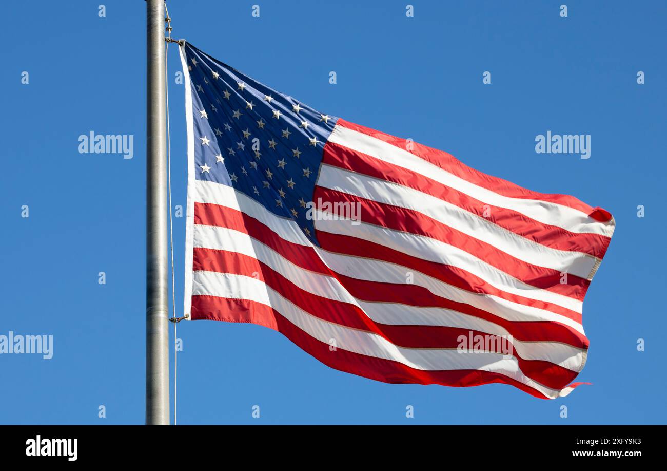 Die amerikanische Flagge winkt im Wind gegen den blauen Himmel Stockfoto