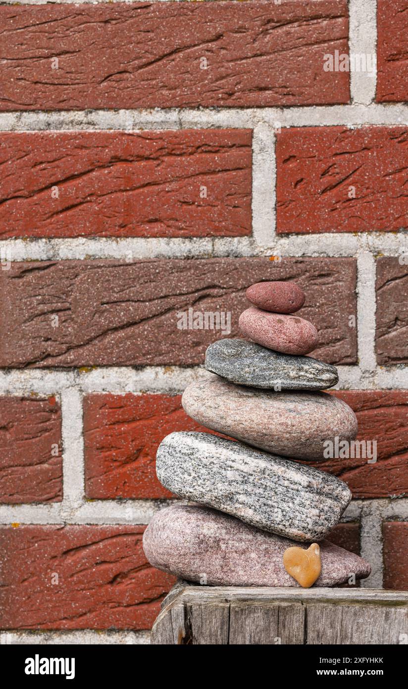 Dekorativ gestaltet mit Flotsam und Jetsam und gestapelten Steinen, Herzstein, Gartendekoration Stockfoto