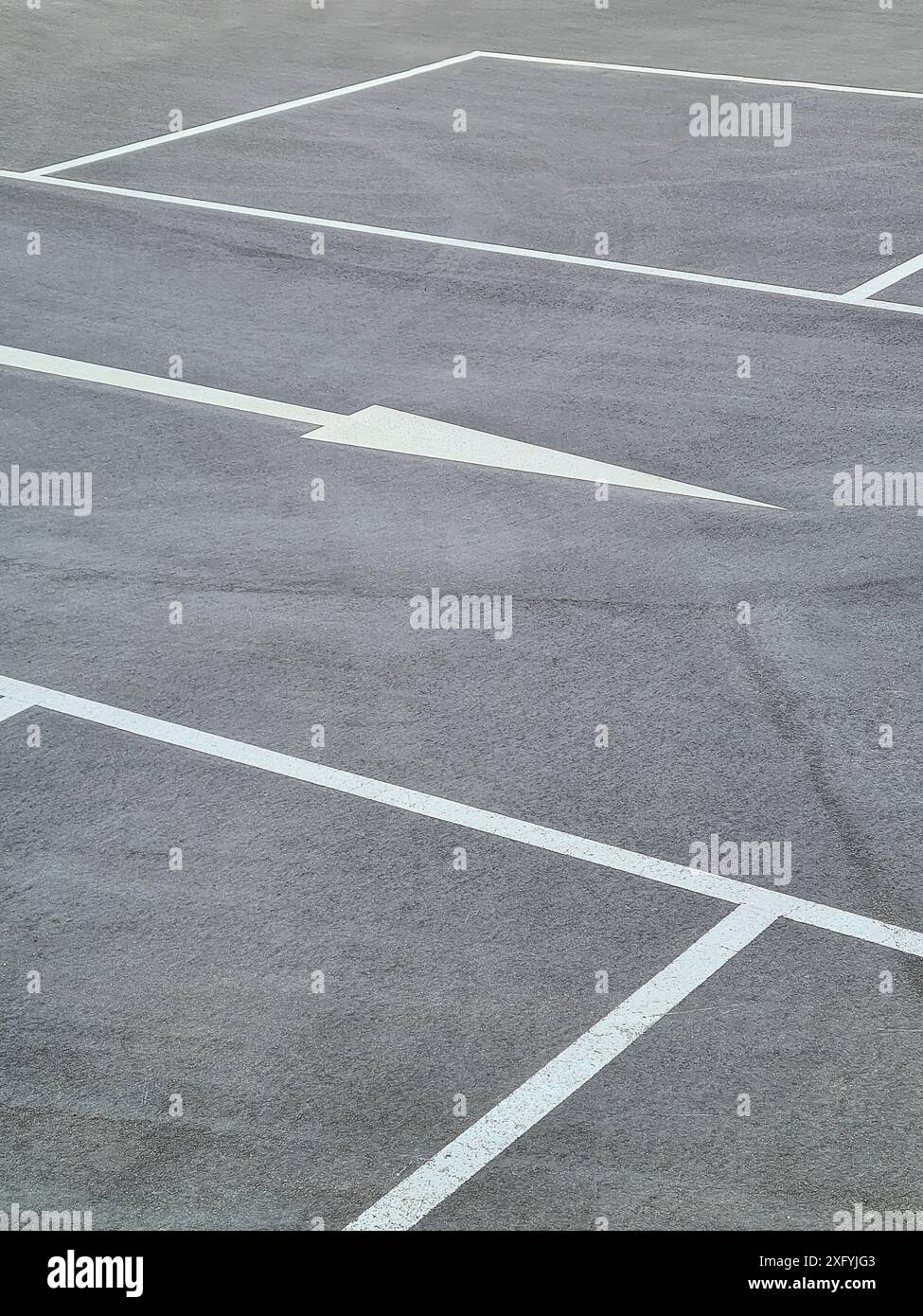Ein Parkplatz mit weißen Markierungen für die Parkbuchten und weißen Pfeilen für die Fahrtrichtung, Parkordnung in Nordrhein-Westfalen Stockfoto