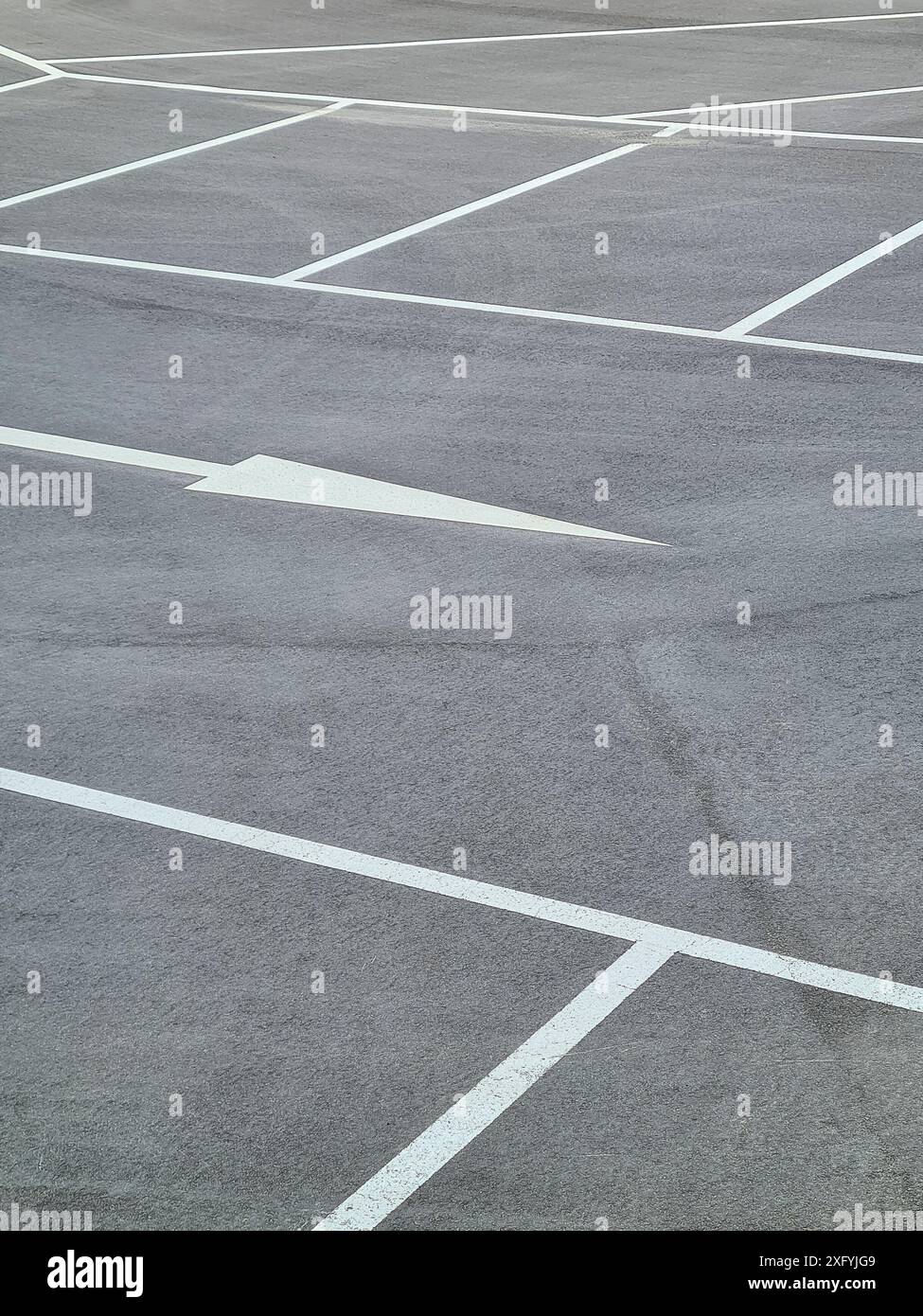 Ein Parkplatz mit weißen Markierungen für die Parkbuchten und weißen Pfeilen für die Fahrtrichtung, Parkordnung in Nordrhein-Westfalen Stockfoto