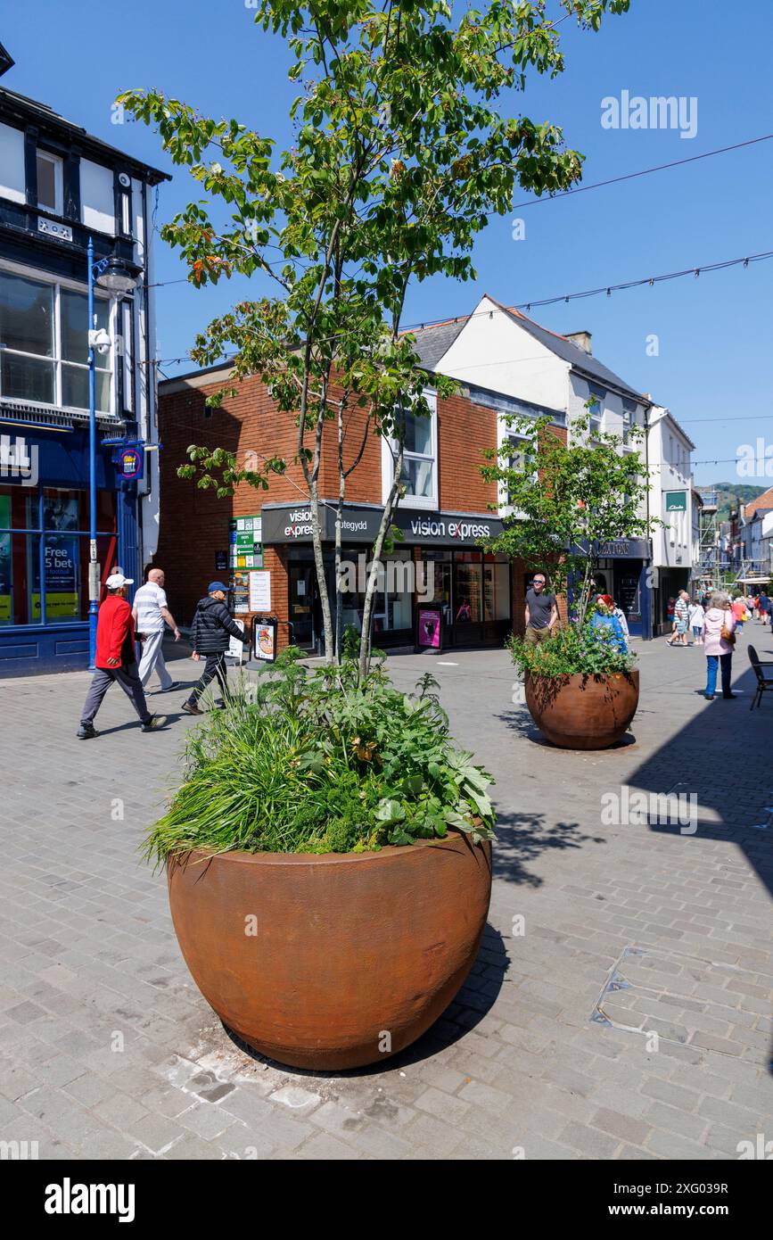 Einkaufsstraße mit roten Metallgefäßen, Abergavenny, Wales, Großbritannien Stockfoto