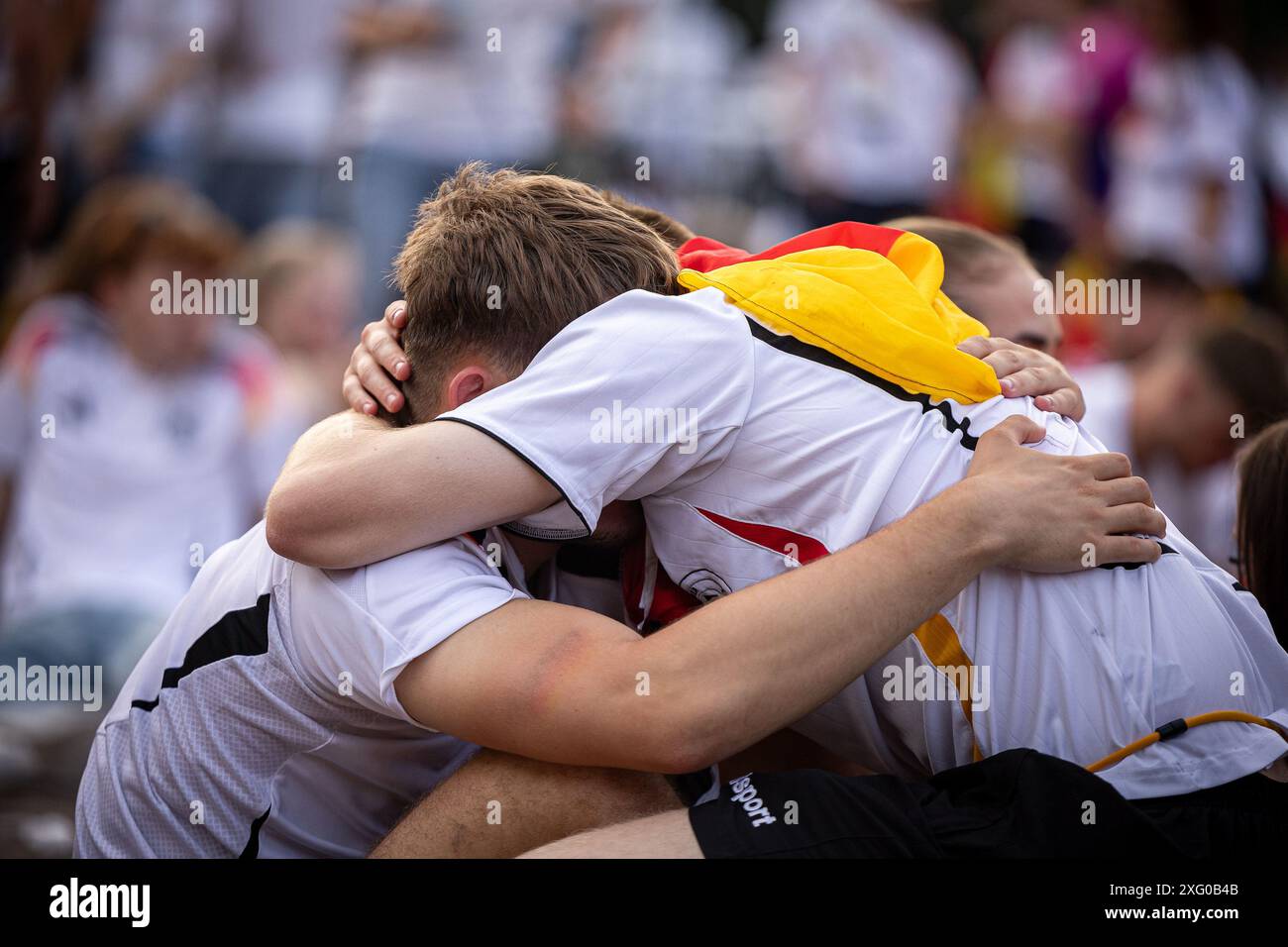 Zwei deutschland Fans sitzen niedergeschlagen am Boden und umarmen sich gegenseitig. Fans der deutschen Nationalmannschaft liegen in Traenen nach dem Spiel gegen Spanien und dem Ausscheiden aus der EURO2024 beim Fanfest mit Public Viewing auf dem Stuttgarter Schlossplatz. Foto: Eibner-Pressefoto/Dennis Duddek Stockfoto