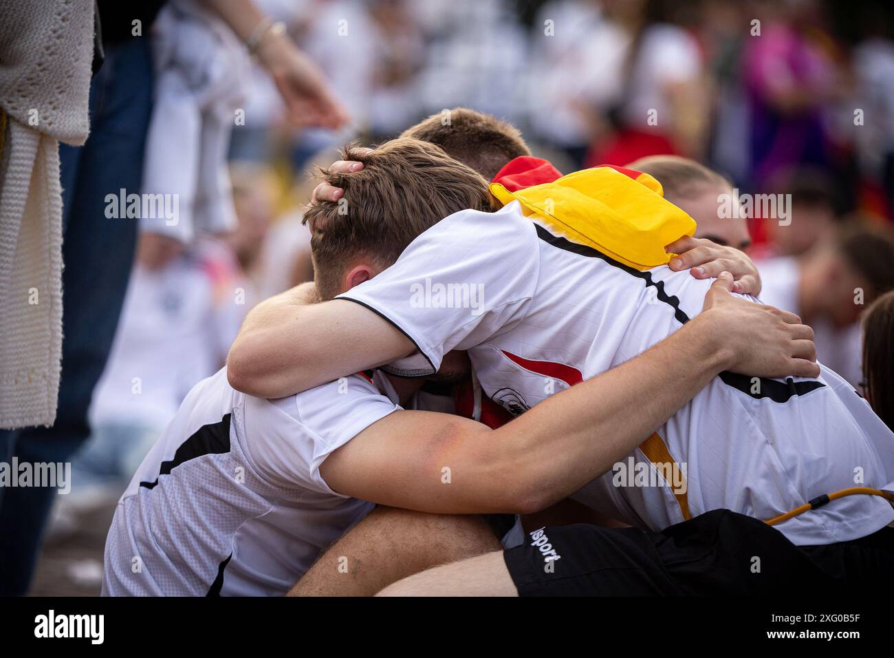 Zwei deutschland Fans sitzen niedergeschlagen am Boden und umarmen sich gegenseitig. Fans der deutschen Nationalmannschaft liegen in Traenen nach dem Spiel gegen Spanien und dem Ausscheiden aus der EURO2024 beim Fanfest mit Public Viewing auf dem Stuttgarter Schlossplatz. Foto: Eibner-Pressefoto/Dennis Duddek Stockfoto