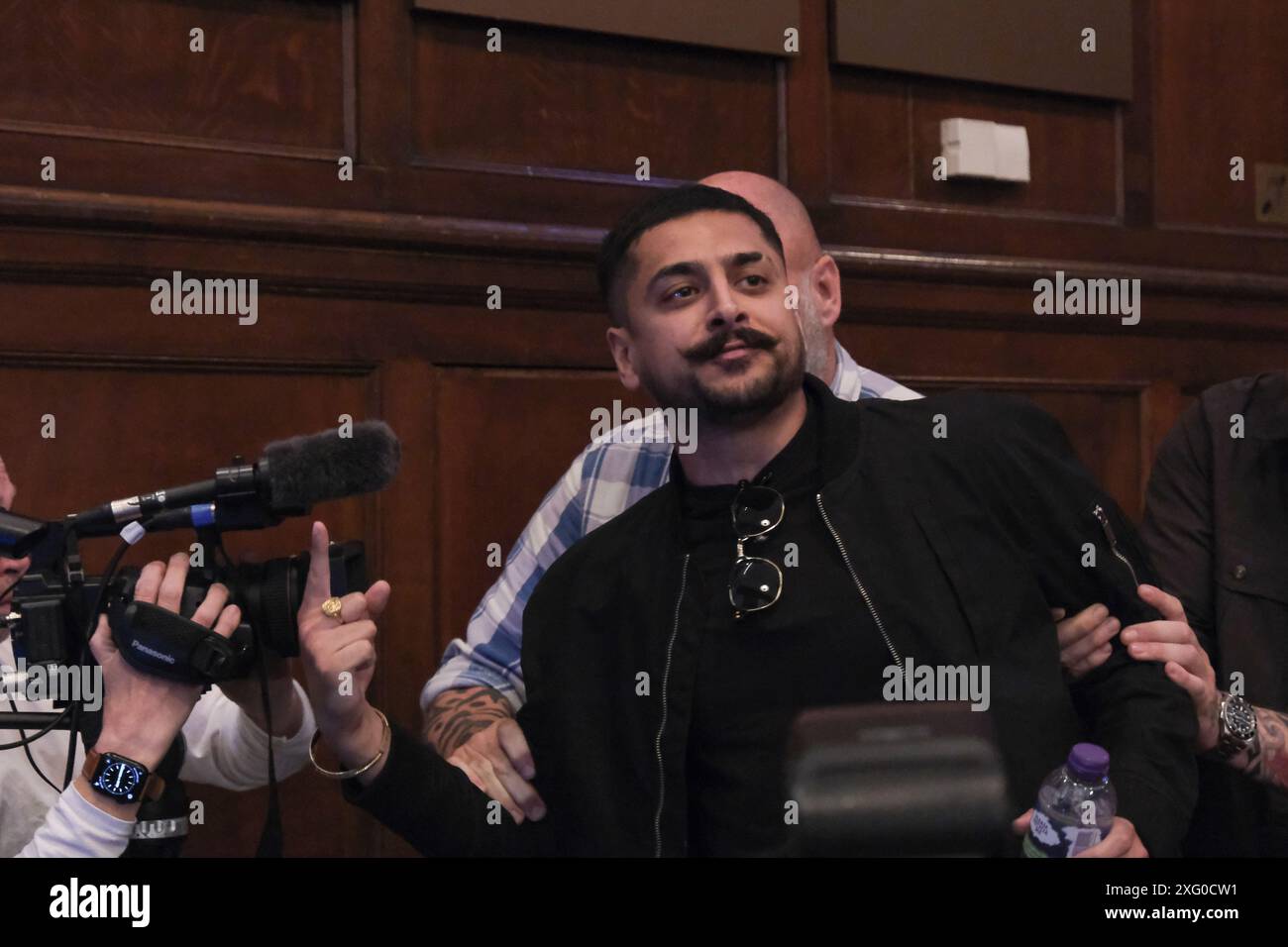 London, UK, 5. Juli 2024. Ein Aktivist von Stand Up to Rassismus wird von einer Reform UK Pressekonferenz in Westminster begleitet, nachdem die Partei vier Sitze bei den Parlamentswahlen (zum Zeitpunkt der Veranstaltung) gewonnen hatte. Es wurden Reden gehalten und Fragen von Medienvertretern gestellt. James McMurdock wurde einige Stunden später als fünfter Parlamentsabgeordneter bekannt gegeben und wurde für South Basildon und East Thurrock gewählt. Quelle: Eleventh Photography/Alamy Live News Stockfoto